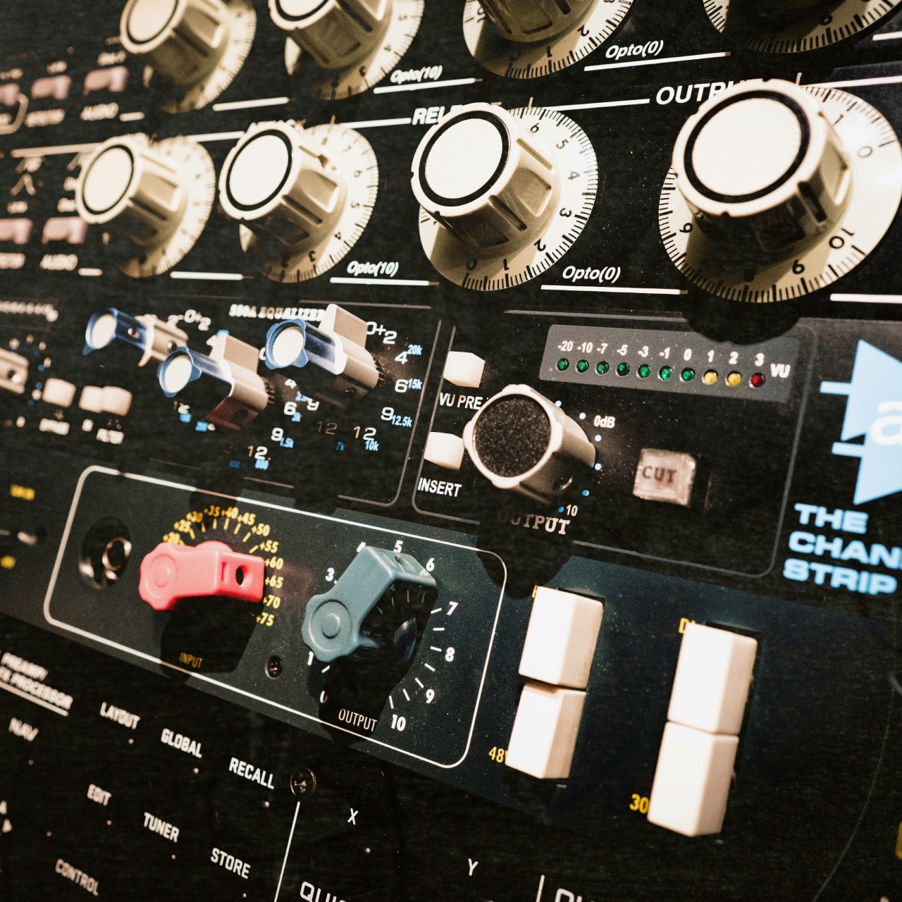 Close-up of various vintage analog gear, including a channel strip, equalizer, and compressor